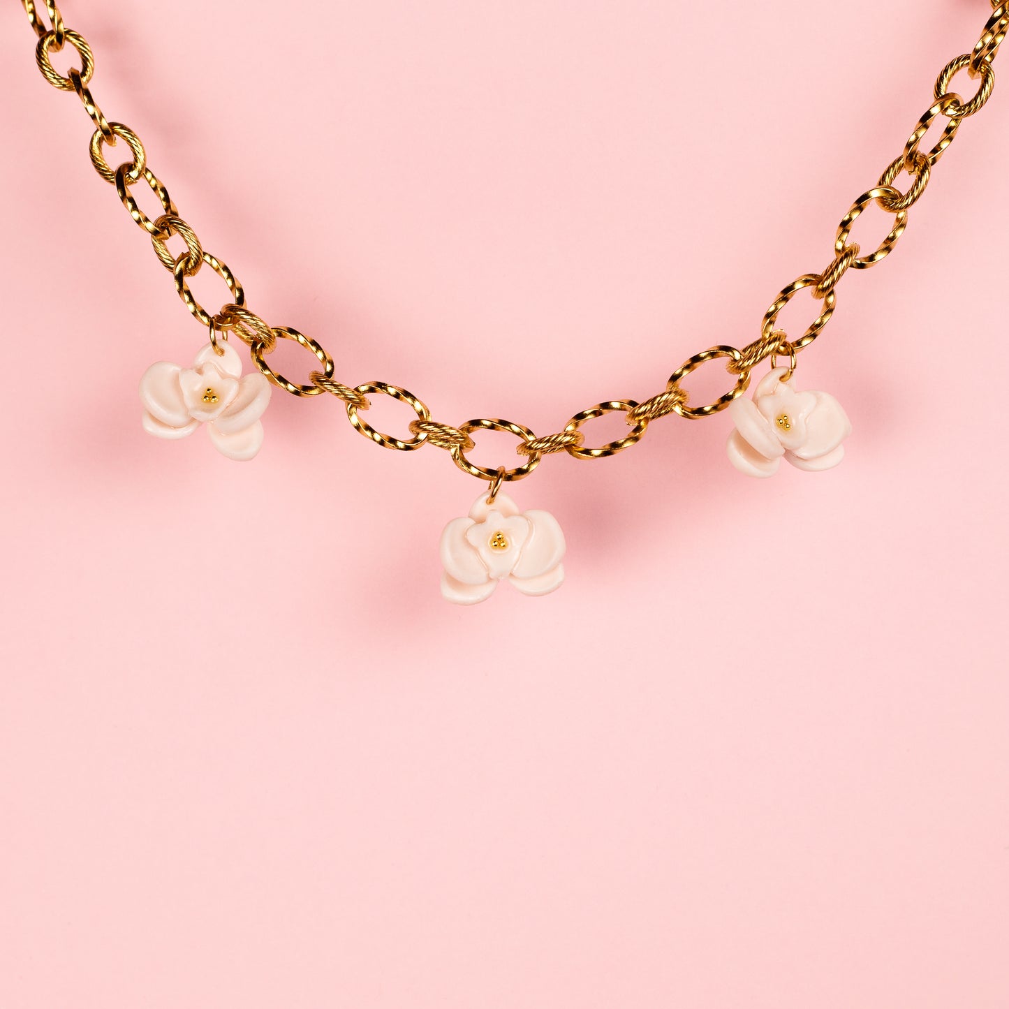 Collar de acero inoxidable con charms de arcilla polimérica de orquídeas hechos a mano.
