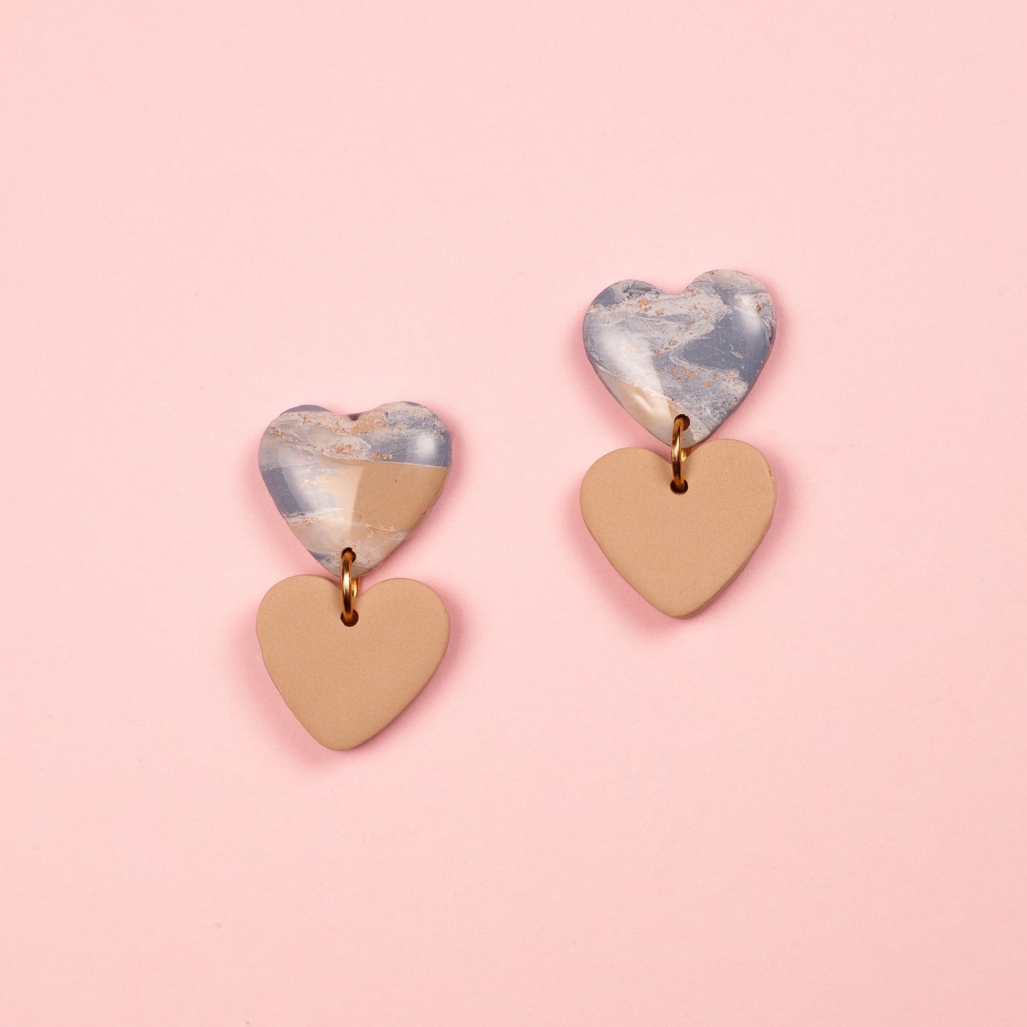 Pendientes de arcilla polimérica y acero inoxidable hechos a mano. Dos corazones, uno cuelga debajo de otro.