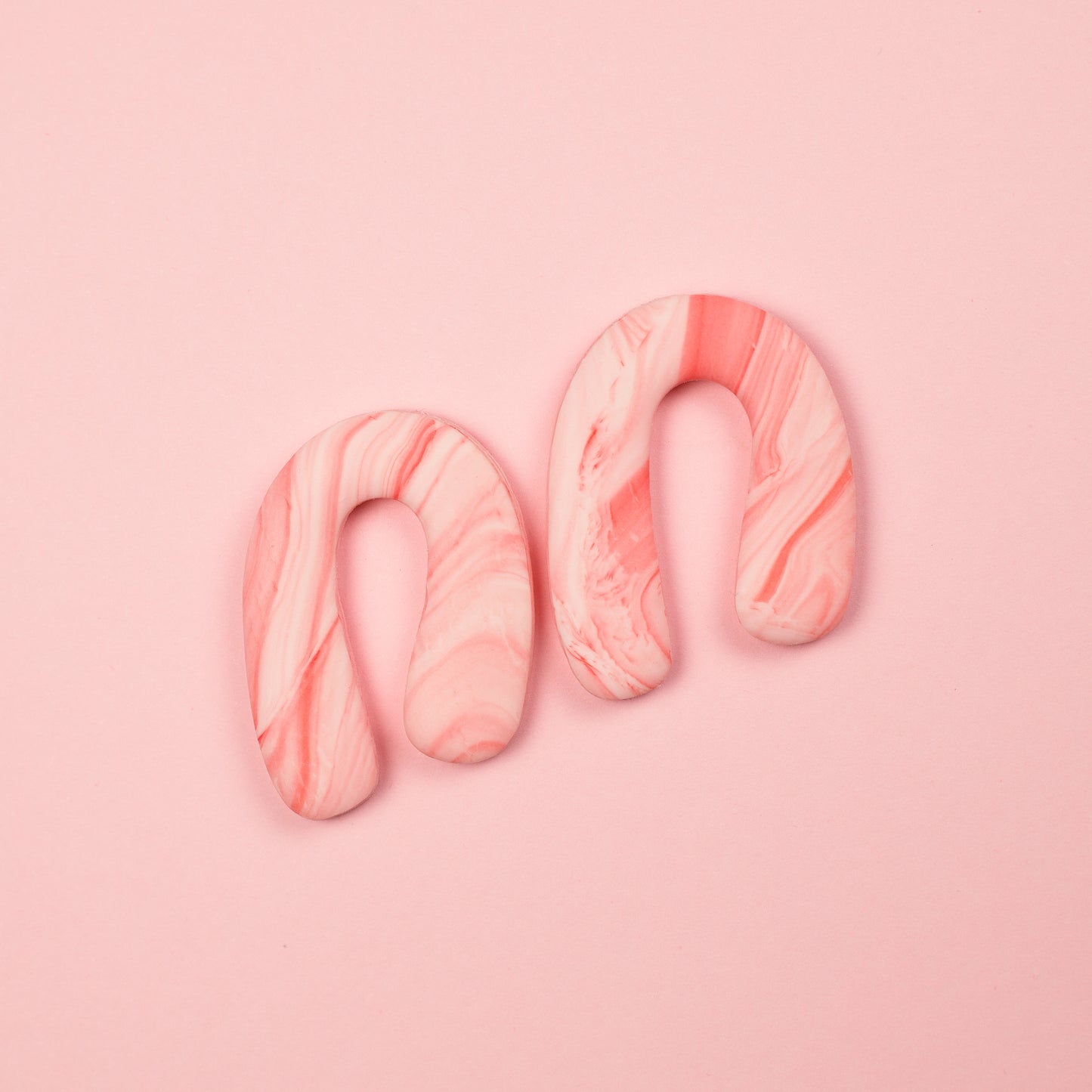 Pendientes de arcilla polimérica en forma de arco asimétrico en tonos rosados y blancos. Hechos a mano.