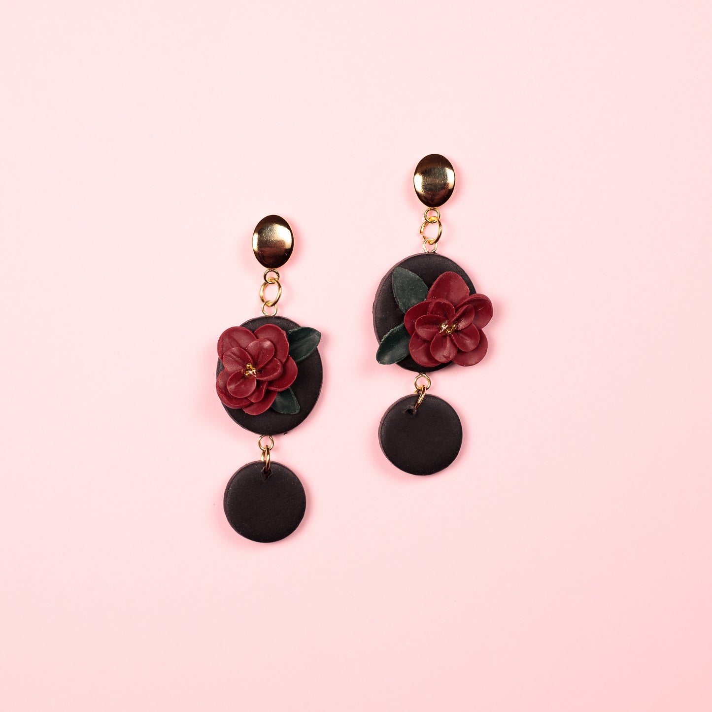 Pendientes de arcilla polimérica y acero inoxidable hechos a mano con forma de circulos y una flor en medio.