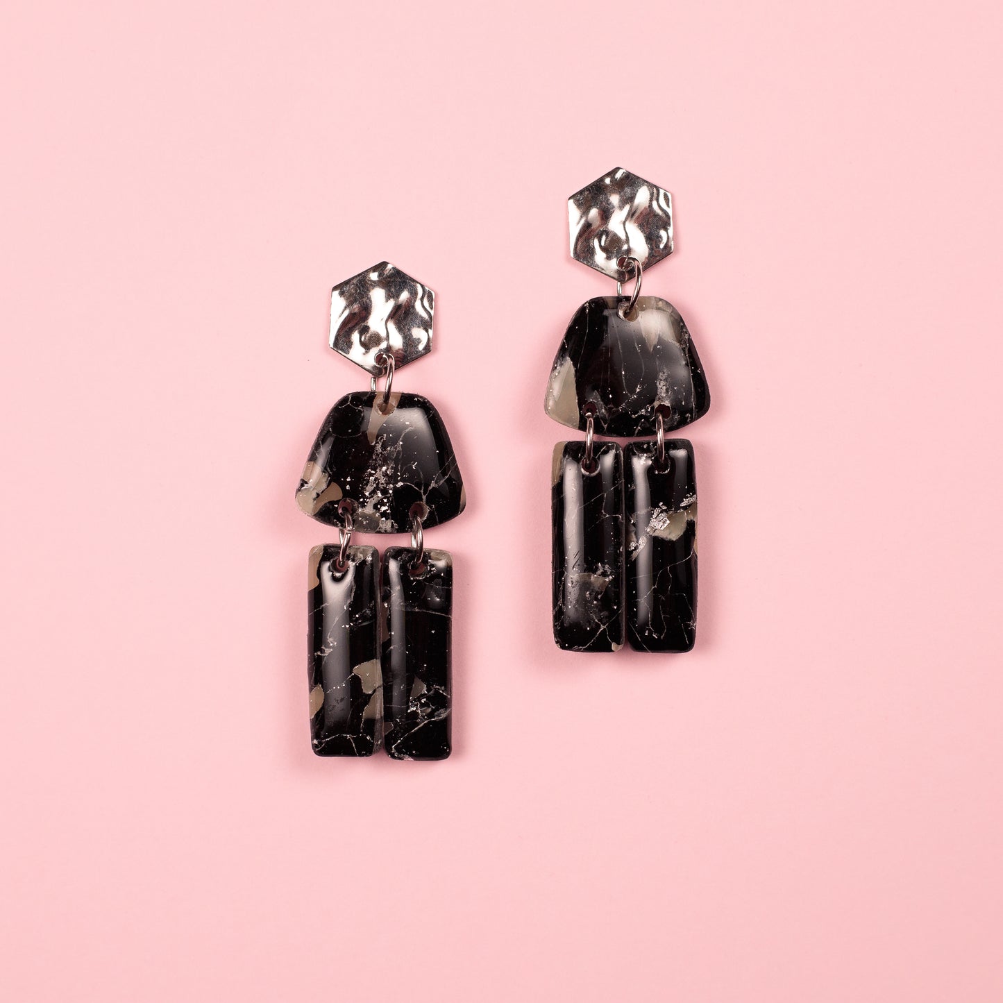 Pendientes hechos a mano en arcilla polimérica y acero inoxidable con formas geométricas.