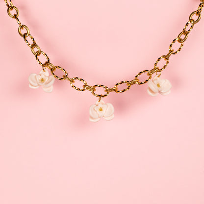 Collar de acero inoxidable con charms de arcilla polimérica de orquídeas hechos a mano.