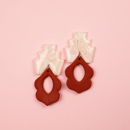 Pendientes de arcilla polimérica y acero inoxidable con formas geométricas y textura abstracta en color blanco y teja.