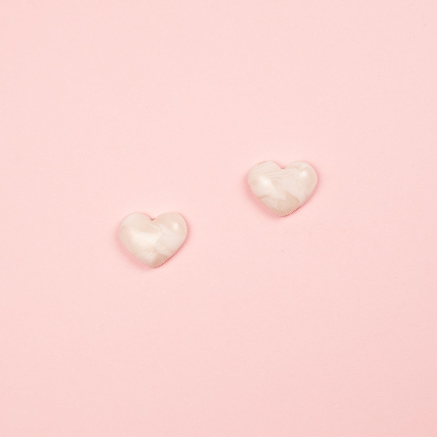 Pendientes de arcilla polimérica y acero inoxidable  hechos a mano con forma de corazón en blanco.
