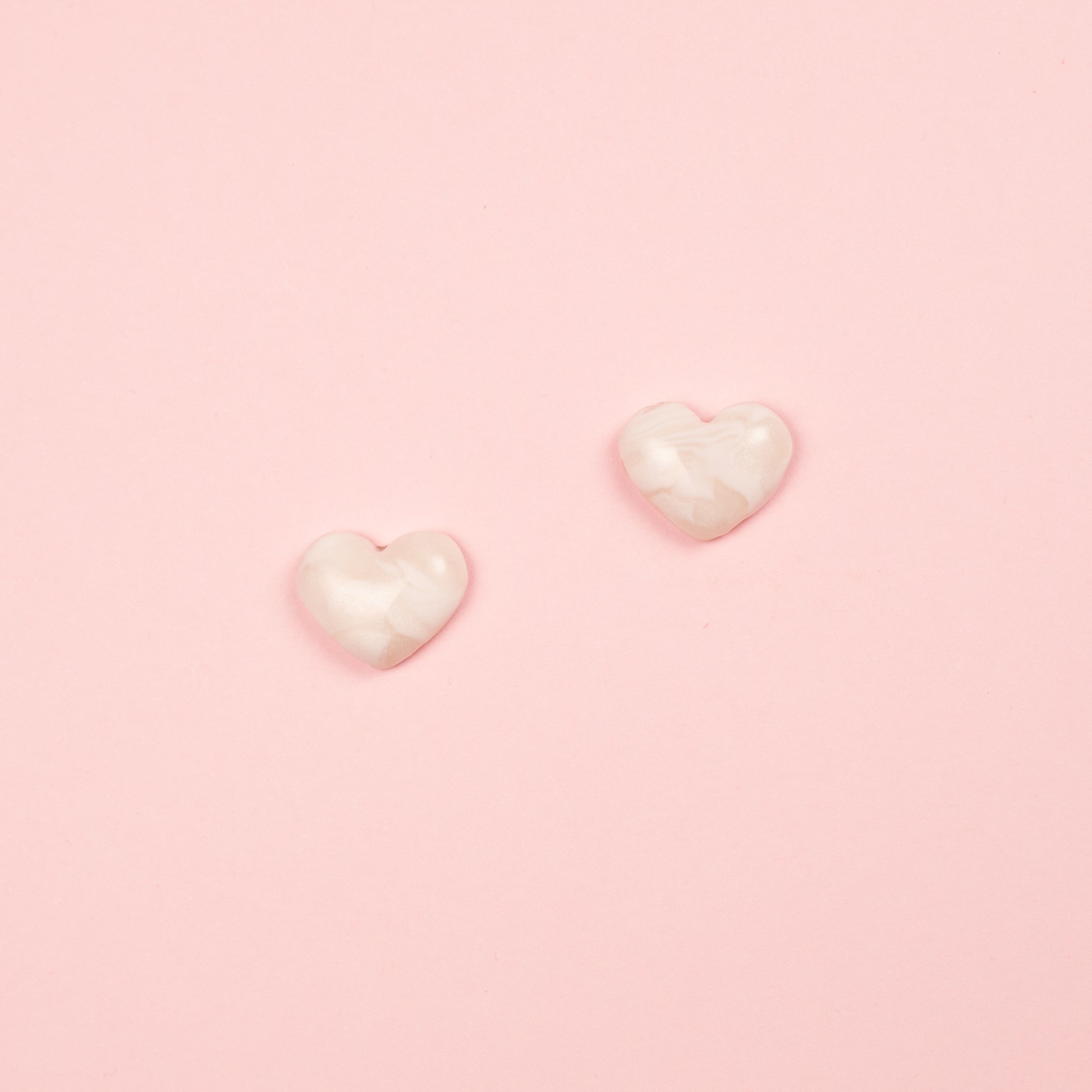 Pendientes de arcilla polimérica y acero inoxidable  hechos a mano con forma de corazón en blanco.