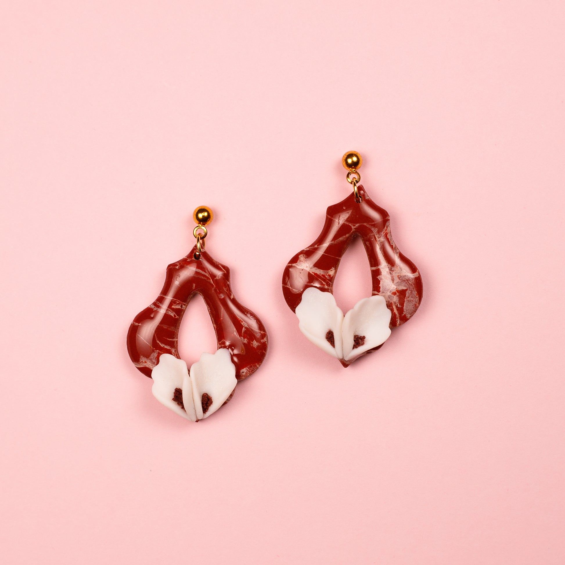 Pendientes de arcilla polimérica y acero inoxidable hechos a mano con forma geométrica y calas blancas.