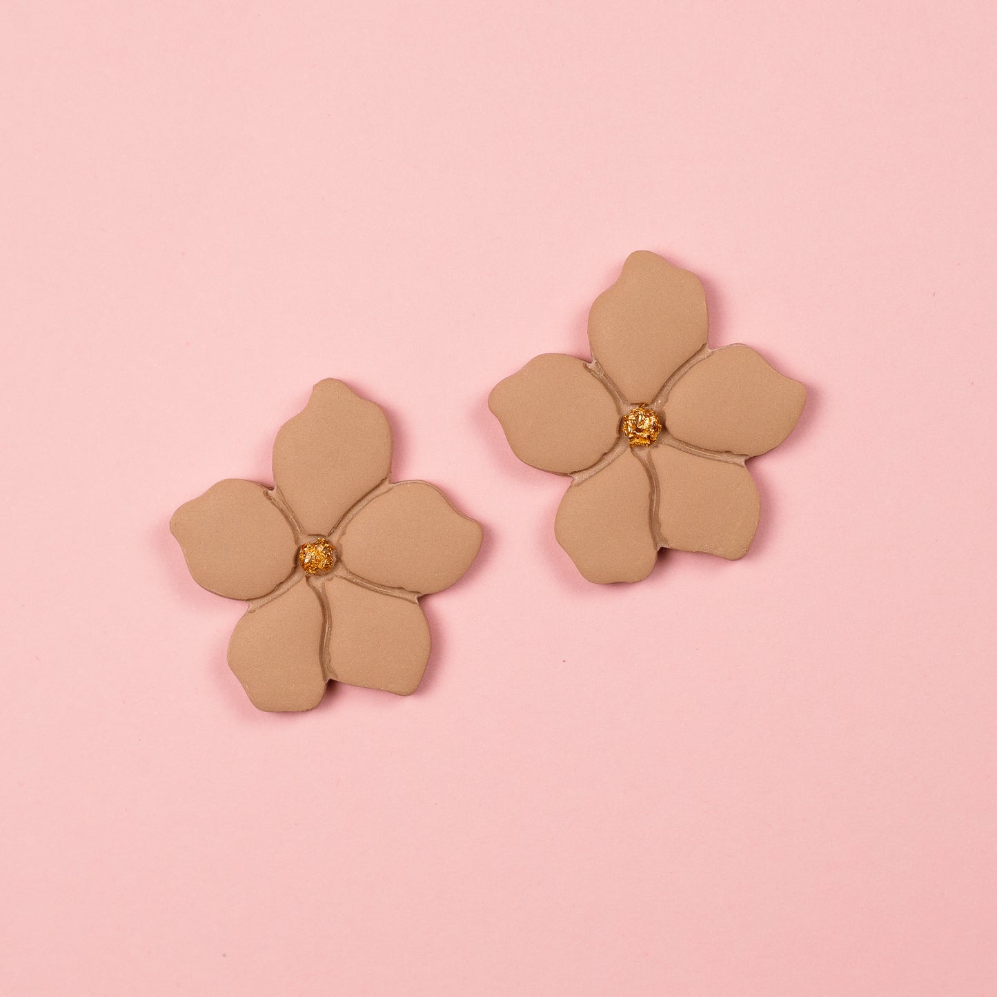 Pendientes de arcilla polimérica y acero inoxidable en forma de flor en tonos beige y dorados.