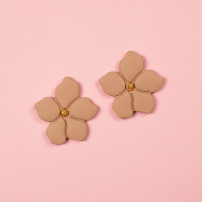 Pendientes de arcilla polimérica y acero inoxidable en forma de flor en tonos beige y dorados.