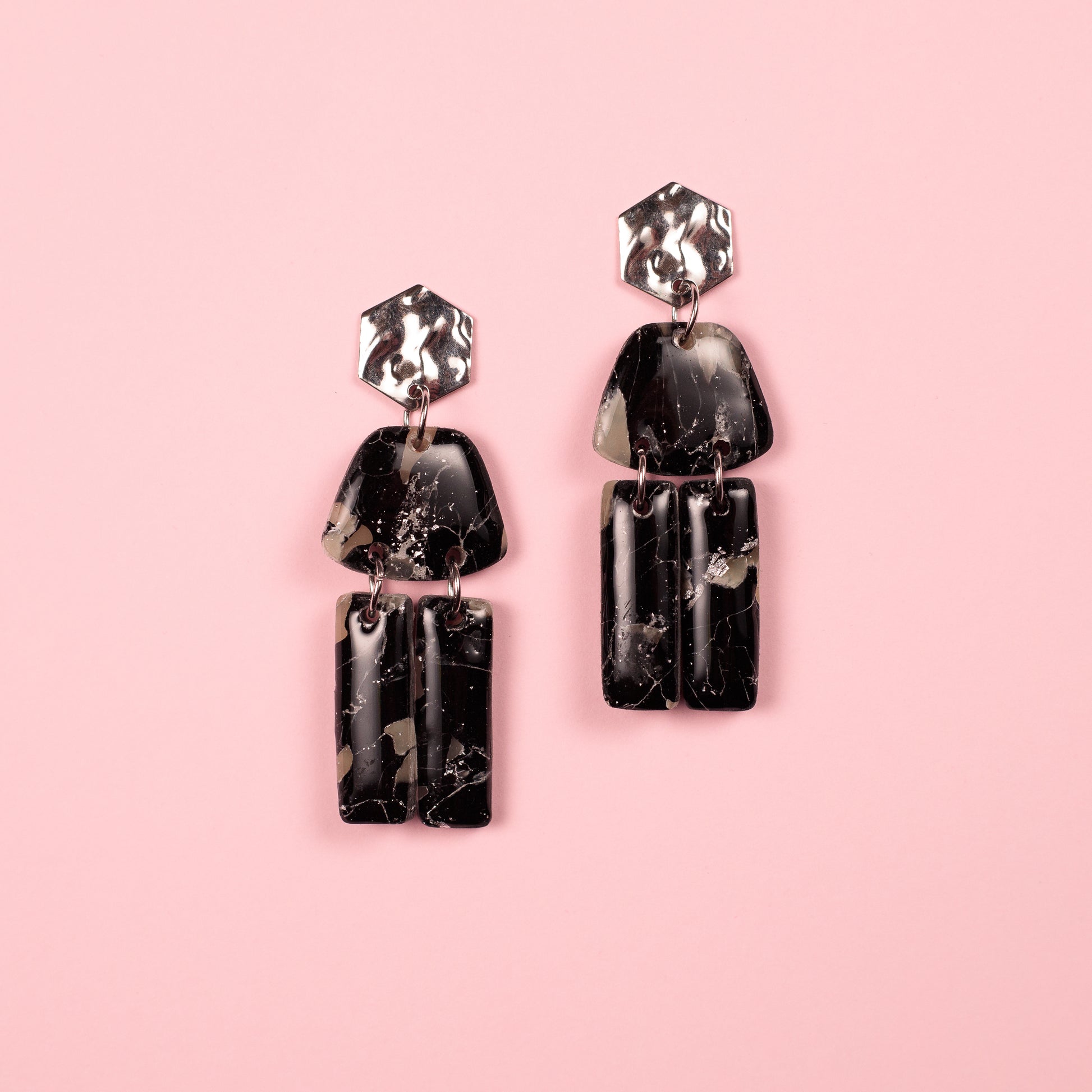 Pendientes hechos a mano en arcilla polimérica y acero inoxidable con formas geométricas.