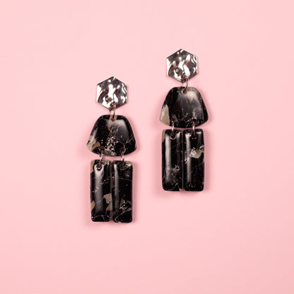 Pendientes hechos a mano en arcilla polimérica y acero inoxidable con formas geométricas.