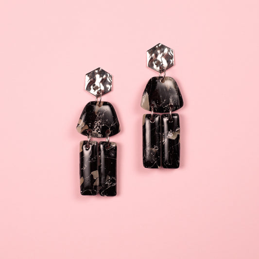 Pendientes hechos a mano en arcilla polimérica y acero inoxidable con formas geométricas.