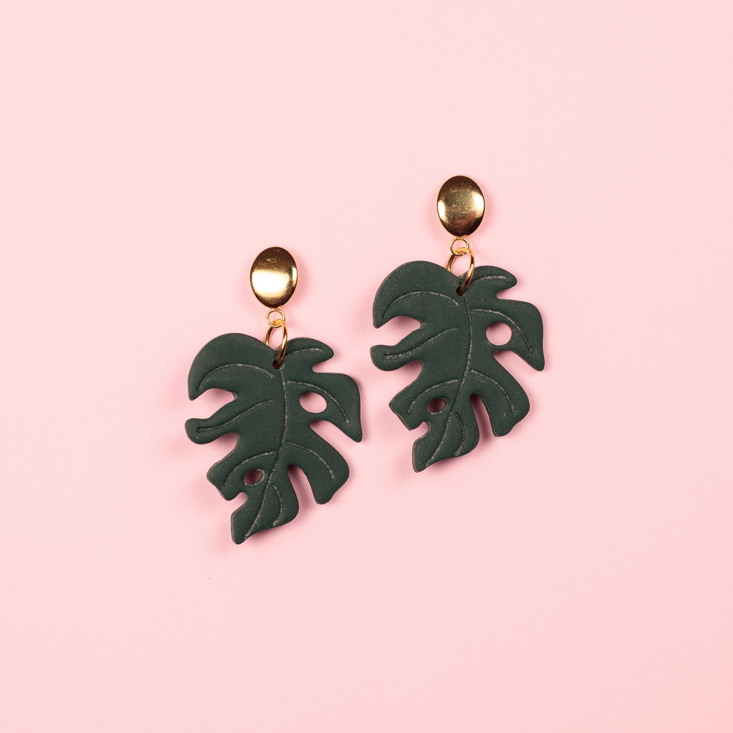 Pendientes hechos a mano con forma de hoja de monstera de arcilla polimérica  con enganche ovalado en acero dorado.