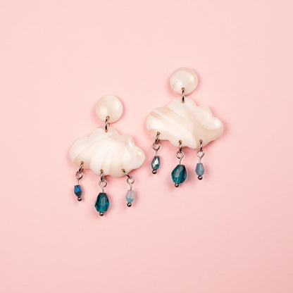 Pendientes de acero inoxidable y arcilla polimérica hechos a mano en forma de nube blanca con cuentas de vidrio que simulan la lluvia.