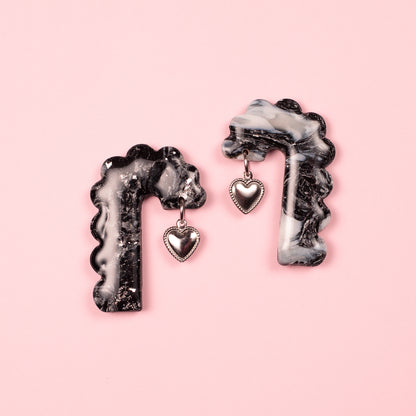 Pendientes hechos a mano con arcilla polimérica y acero inoxidable en forma de arco con charm decorativo de corazón.