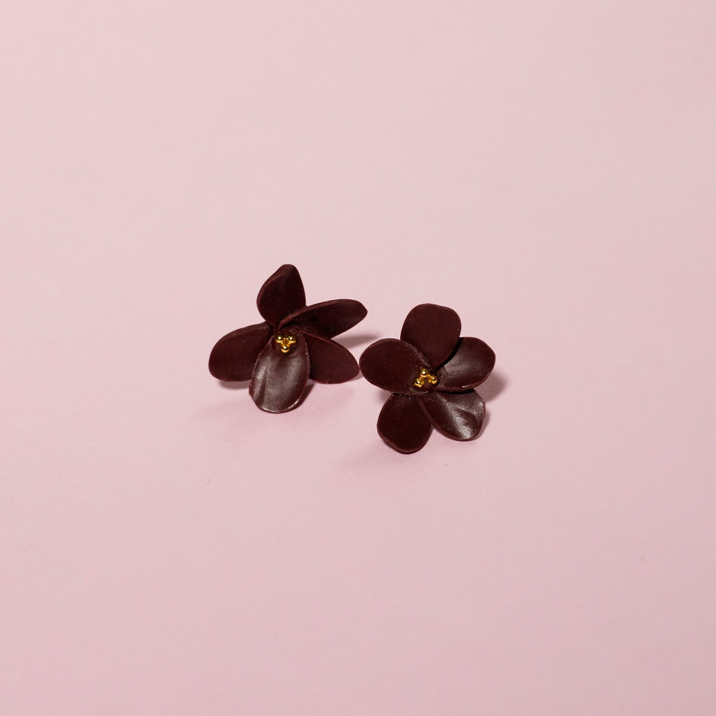 Pendientes de arcilla polimérica en color burdeos con diseño de floral y detalles dorados.
