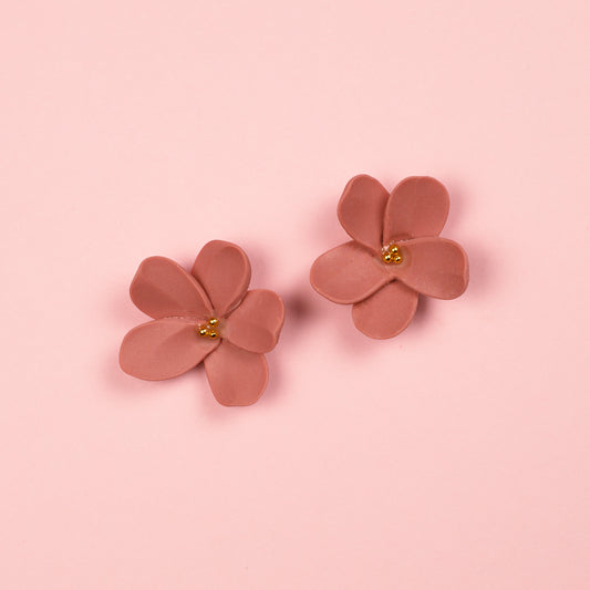 Pendientes de botón hechos a mano de arcilla polimérica y acero inoxidable con diseño de flor en rosa sucio y detalles dorados.
